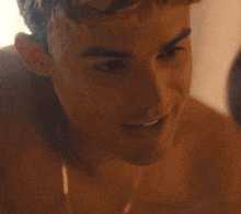 a close up of a shirtless man 's face smiling