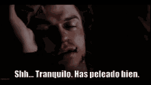a man is laying in a dark room with his hand on his forehead and the words `` tranquilo has peleado bien '' .