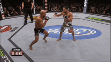 two men are fighting in a boxing ring with the time 2:56 on the screen