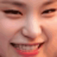 a close up of a woman 's face with a smile and red lips .