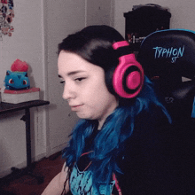 a woman wearing headphones sits in a typhon gaming chair