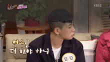 a man sitting on a couch with a name tag that says kbs2