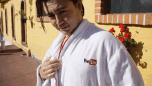 a person wearing a white robe with a youtube logo on the front