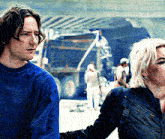 a man and a woman are standing next to each other and the man is wearing a blue shirt