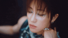 a close up of a woman 's face with a ring on her neck