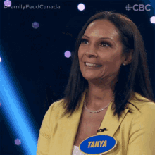 a woman wearing a yellow jacket and a name tag that says tanya