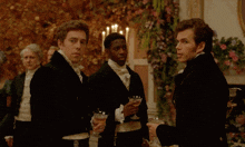 a man in a tuxedo holds a glass of champagne