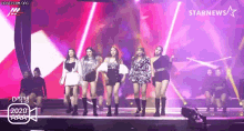 a group of women are dancing on a stage in front of a star news logo .