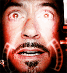 a close up of a man 's face with his eyes wide open