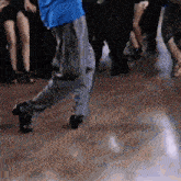 a man in a blue shirt is dancing on a dance floor .
