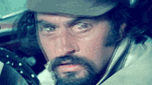 a man with a beard is wearing a hat