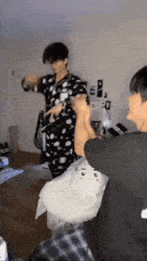 a group of young men are standing in a room playing with a stuffed animal .