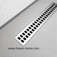 a stainless steel shower drain is sitting on a tiled floor in a bathroom .