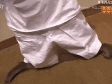 a person wearing white shorts is kneeling down on the floor