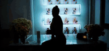 a silhouette of a woman sitting on a table in front of a display of magazines .