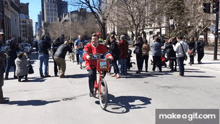 a man in a red jersey with the number 55 on it is riding a bike down a street