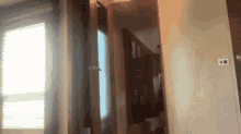 a hallway with a door that is open and a window