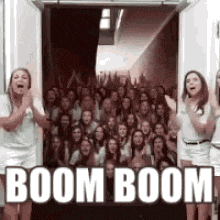 a group of people are standing in front of a door with the words boom boom .