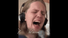 a man wearing headphones is singing into a microphone with the words he scream written on the bottom