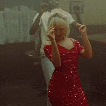 a woman in a red dress is dancing with two men