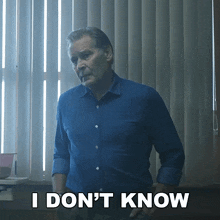a man in a blue shirt says " i don 't know " in white letters