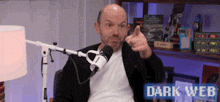 a man is giving a thumbs up in front of a microphone with the words dark web behind him .