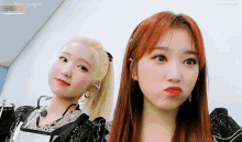 two girls are posing for a picture and one of them is wearing a microphone around her neck