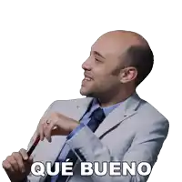 a man in a suit and tie is smiling and holding a cane with the words que bueno written below him