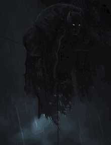 a man in a batman costume is hanging from a rope .