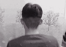 a black and white photo of a man 's head with trees in the background .