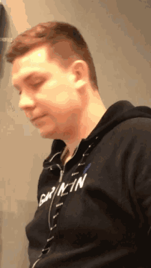 a man wearing a black hoodie that says calvin klein