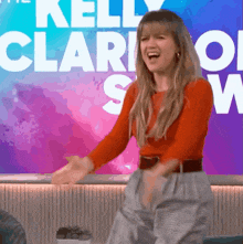 a woman is dancing in front of a sign that says kelly clark show