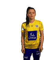 a woman wearing a yellow shirt with the word uniqa on it