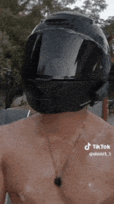 a man without a shirt is wearing a helmet on his head