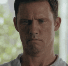 a man in a white shirt is making a funny face .