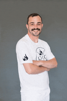 a man with his arms crossed wears a white shirt with a picture of a ghost on it