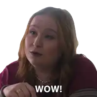 a woman with red hair and a ring on her finger has the word wow on her face