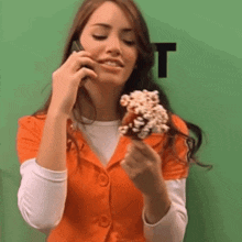a woman is talking on a cell phone while holding an ice cream bar
