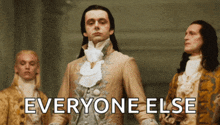 a man in a suit stands next to two other men with the words everyone else below him