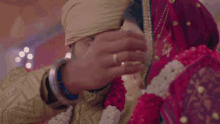 a man is putting a nose ring on the nose of a woman