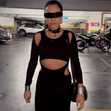 a woman wearing sunglasses and a choker stands in a parking lot