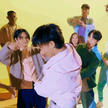 a group of people are dancing in front of a yellow background with the words gwentealeaves on the bottom right