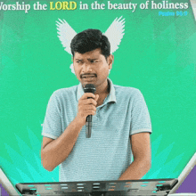 a man speaking into a microphone in front of a sign that says psalm 96:9