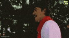 a man wearing a white shirt and a red scarf is looking up