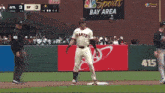 a baseball player wearing a giants jersey is standing on the base
