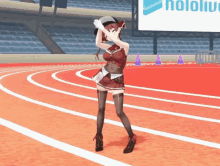 a girl is dancing on a track with a hololive sign in the background