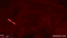 a man playing a keyboard in a dark room with a gifrun.com watermark