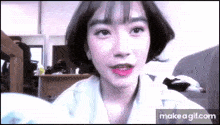 a close up of a woman 's face with short hair and red lipstick .