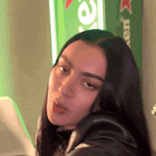 a close up of a woman 's face with a heineken sign in the background