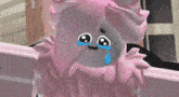 a cartoon character with pink hair is crying with a tear coming out of her eye .